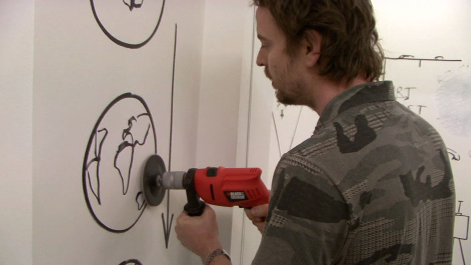 Video still from: Kalin Serapionov. Unmaking Dan, 2010. <br> 12' 59'', collective performance by the Institute of Contemporary Art – Sofia members deleting Dan Perjovschi’s wall drawings after his exhibition at Institute of Contemporary Art – Sofia Gallery in 2010.